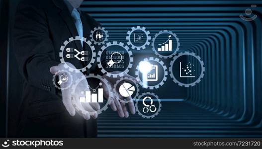 Business data analytics management with connected gear cogs with KPI financial charts and graph.business man with an open hand as showing something concept