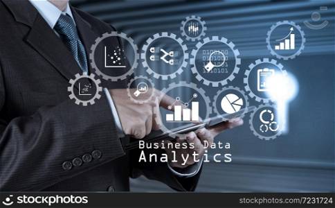Business data analytics management with connected gear cogs with KPI financial charts and graph.businessman hand use smart phone computer as concept