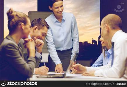 business, deadline and corporate concept - smiling female boss talking to business team at office over city view background. smiling female boss talking to business team