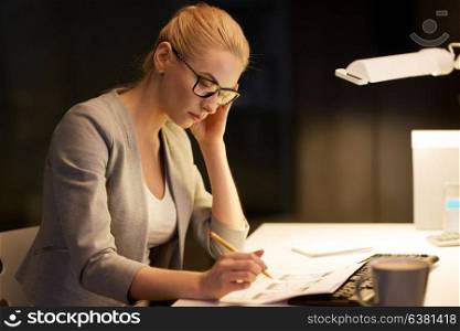 business, deadline and people concept - businesswoman with papers working at night office. businesswoman with papers working at night office