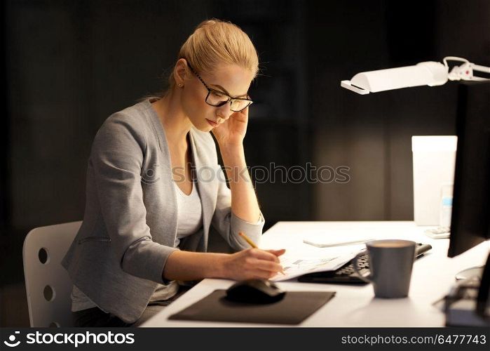 business, deadline and people concept - businesswoman with papers working at night office. businesswoman with papers working at night office. businesswoman with papers working at night office