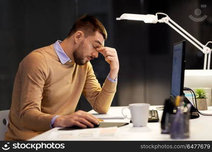 business, deadline and stress concept - tired businessman with computer working at night office. tired businessman working at night office. tired businessman working at night office