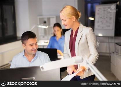business, deadline and technology concept - businesswoman and businessman with papers working late at night office. business team with papers working late at office