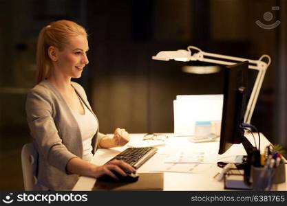 business, deadline and technology concept - businesswoman with computer working at night office. businesswoman at computer working at night office