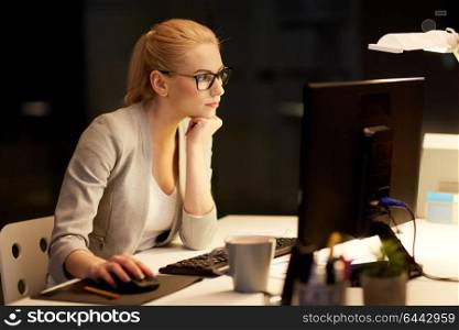 business, deadline and technology concept - businesswoman with computer working at night office. businesswoman at computer working at night office