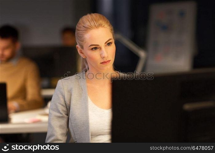 business, deadline and technology concept - businesswoman with computer working at night office. businesswoman at computer working at night office. businesswoman at computer working at night office