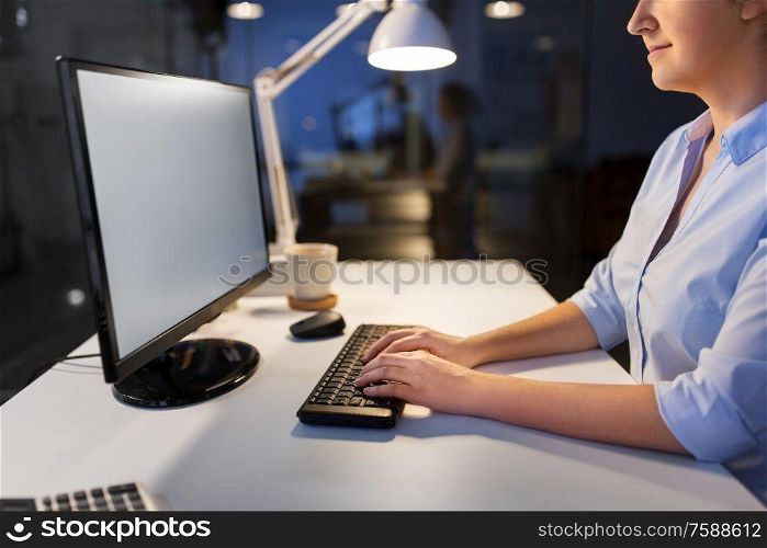 business, deadline and technology concept - businesswoman with computer working at night office. businesswoman working on computer at night office