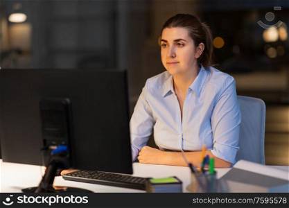 business, deadline and technology concept - businesswoman with computer working at night office. businesswoman working on computer at night office