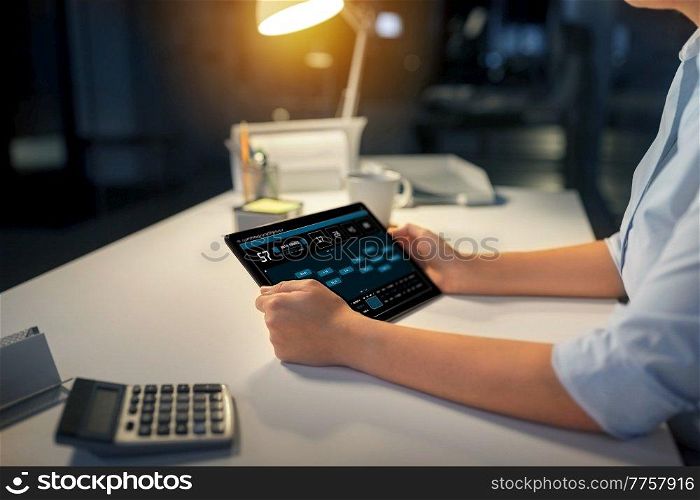business, deadline and technology concept - businesswoman with data on tablet pc computer working at night office. businesswoman with tablet computer at night office