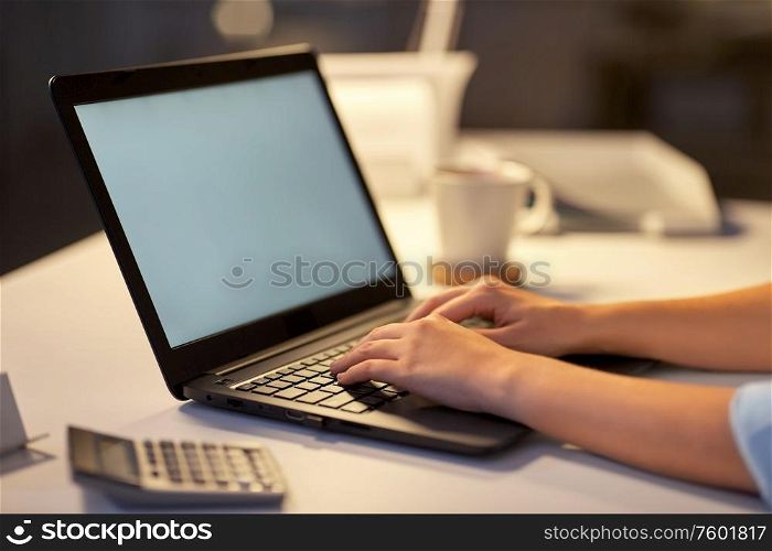 business, deadline and technology concept - businesswoman with laptop computer working at dark night office. businesswoman with laptop at dark night office