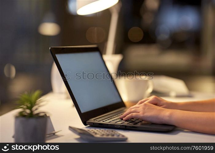 business, deadline and technology concept - businesswoman with laptop computer working at dark night office. businesswoman with laptop at dark night office