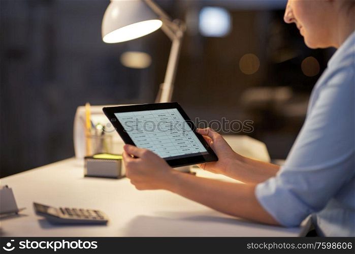 business, deadline and technology concept - businesswoman with open file on tablet pc computer working at night office. businesswoman with tablet computer at night office