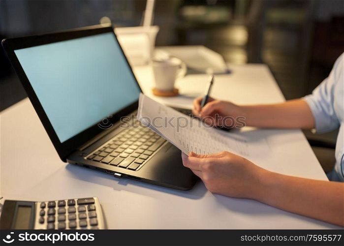 business, deadline and technology concept - businesswoman with papers and computer working at night office. businesswoman with papers working at night office
