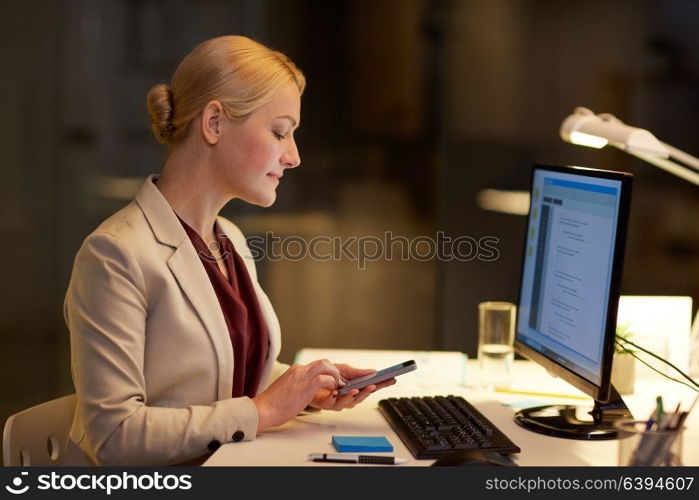 business, deadline and technology concept - businesswoman with smartphone and computer working at night office. businesswoman with smartphone at night office