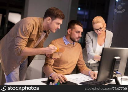 business, deadline and technology concept - coworkers with computer and takeout food working late at night office. business team with computer working late at office