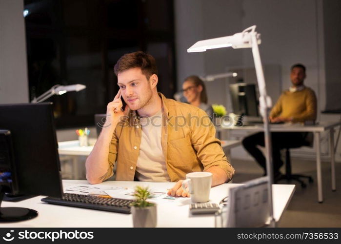 business, deadline and technology concept - man with computer calling on smartphone at night office. man calling on smartphone at night office