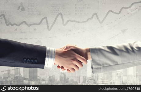 Business deal. Close up of business handshake on digital background