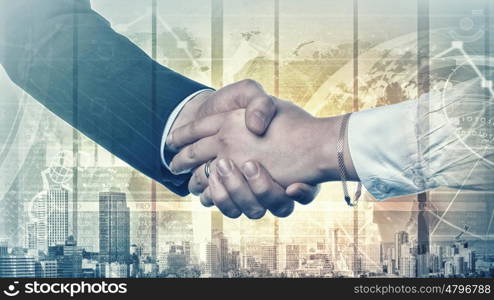 Business deal. Close up of business handshake on digital background