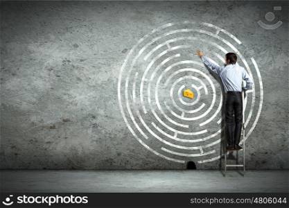 Business decision making. Image of businessman standing on ladder against maze picture