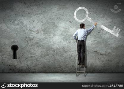 Business decision making. Image of businessman standing on ladder holding key
