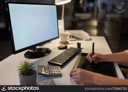 business, design and technology concept - hands of woman or graphic designer with computer and pen tablet working at night office. designer with computer and pen tablet at office