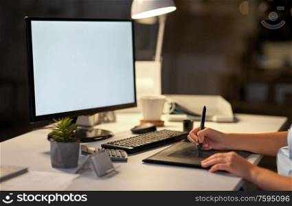 business, design and technology concept - hands of woman or graphic designer with computer and pen tablet working at night office. designer with computer and pen tablet at office