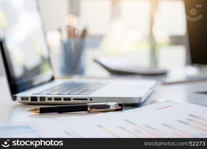 Business desk with a keyboard, report graph chart, pen and tablet on white table