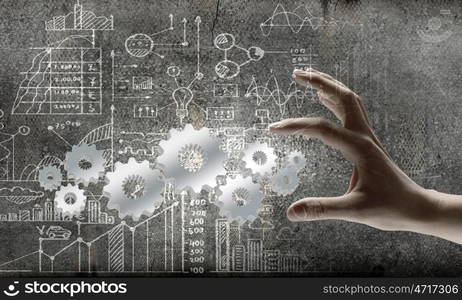 Business development. Close up of businessman hand and cogwheel mechanism