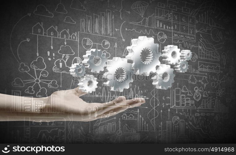 Business development. Close up of businessman hand holding gears in palm