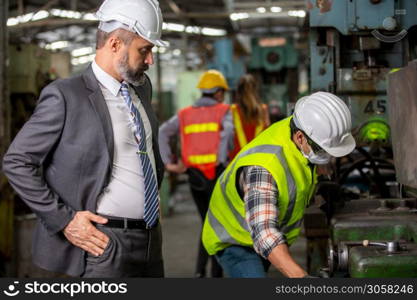 Business director and Mechanic engineer checking and discussing at factory shop floor.