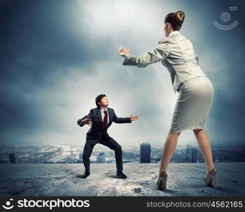 Business dispute. Image of businesspeople arguing and acting as sumo fighters against city background