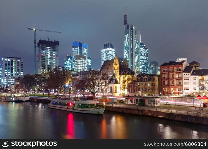 Business district with skyscrapers and Old Town with Roman Catholic church Leonhardskirche in the foreground at night, Frankfurt am Main, Germany