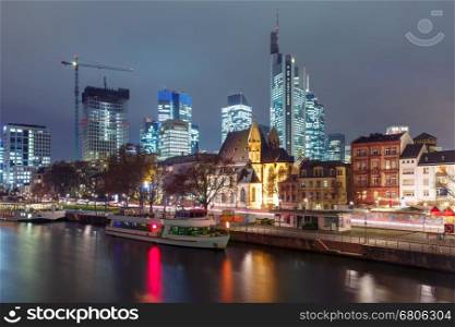 Business district with skyscrapers and Old Town with Roman Catholic church Leonhardskirche in the foreground at night, Frankfurt am Main, Germany