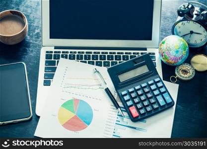 Business document with charts growth,laptop, mobile phone, calcu. Business document with charts growth,laptop, mobile phone, calculator, alarm clock , pen and coffee cup. Workplace businessman. Vintage filtered.