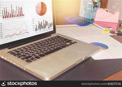 business documents on office table and chart and pen with laptop.