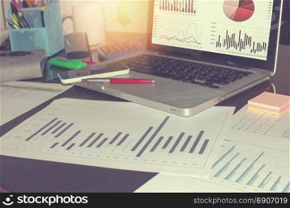 business documents on office table and chart and pen with laptop.