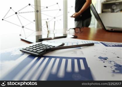 business documents on office table with calculator and digital tablet and man working with smart phone in the background with social network diagram concept
