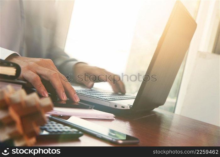 business documents on office table with digital tablet and man working with smart laptop computer background with overcast exposure effect