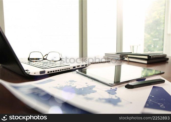 business documents on office table with laptop and digital tablet as work space business concept