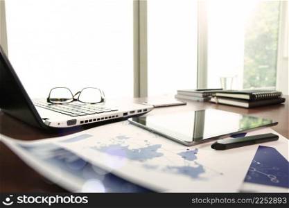 business documents on office table with laptop and digital tablet as work space business concept