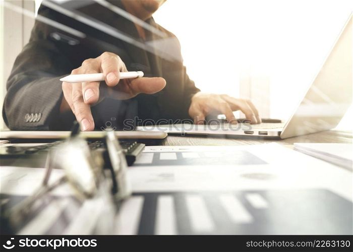 business documents on office table with laptop computer and graph business digital diagram and businessman working in the background