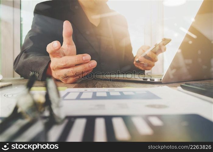 business documents on office table with laptop computer with smart phone and graph business diagram and man working in the background