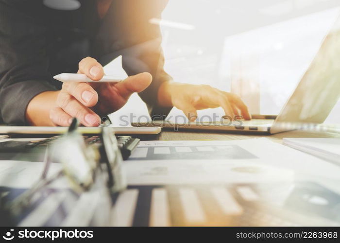 business documents on office table with laptop computer with smart phone and graph business diagram and man working in the background