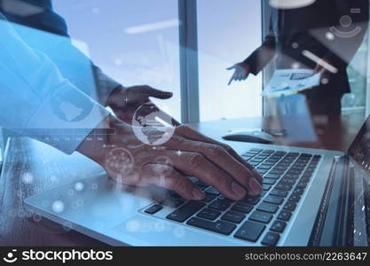 business documents on office table with smart phone and blank screen laptop computer and graph business diagram and two colleagues discussing data in the background