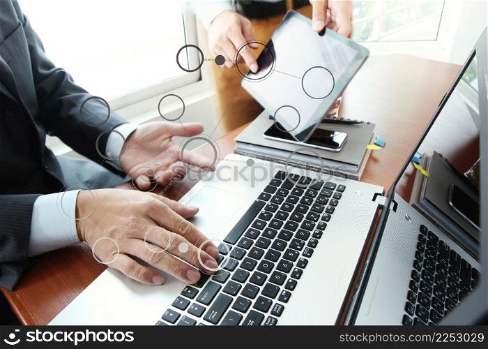 business documents on office table with smart phone and digital tablet and stylus and two colleagues discussing data in the background with blank diagram