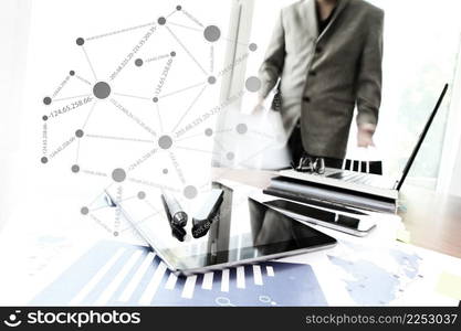 business documents on office table with smart phone and digital tablet and graph business diagram and man working in the background