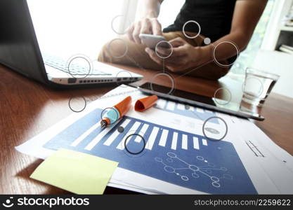 business documents on office table with smart phone and digital tablet and graph business diagram and man working in the background