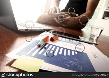 business documents on office table with smart phone and digital tablet and graph business diagram and man working in the background