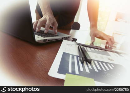 business documents on office table with smart phone and digital tablet and man working in the background