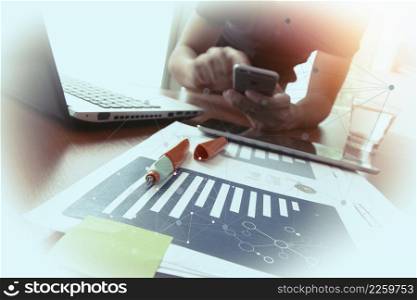 business documents on office table with smart phone and digital tablet and man working in the background with social media diagram